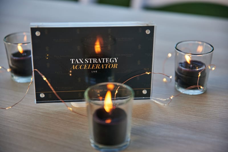 Tax Strategy Accelerator Live table sign surrounded by black candles and string lights