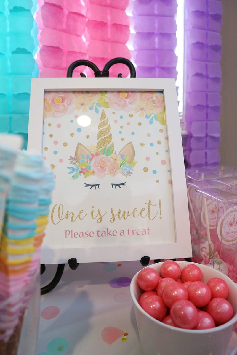 Framed sign reading One is sweet! Please take a treat beside a bowl of pink gumballs